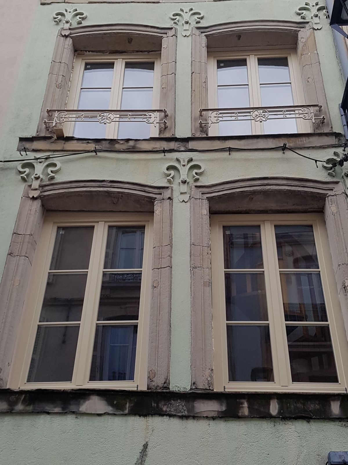 Façade ancienne à encadrements de pierre, fenêtres bois à petits-bois posées