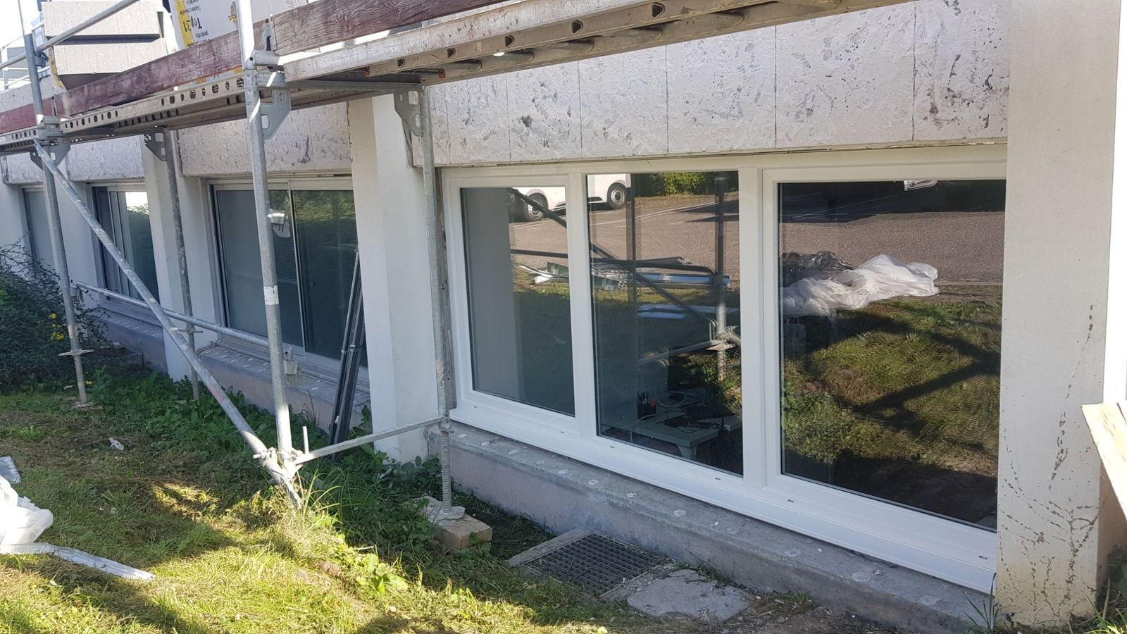 Chantier collectif : fenêtres PVC posées sous échafaudage